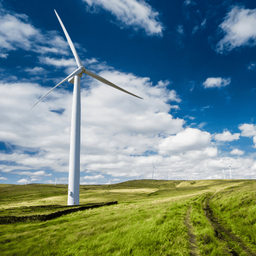 Un aerogenerador se alza en un campo verde, simbolizando la energía renovable y los esfuerzos para reducir el presupuesto de carbono